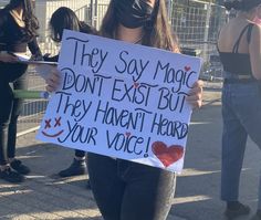 a woman holding a sign that says they say magic don't exit but they haven't heard your voice