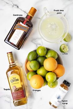 ingredients to make an alcoholic cocktail including limes, oranges and rum