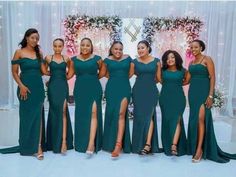 a group of women standing next to each other wearing green dresses and posing for the camera