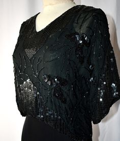 A vintage 1980s retro Edwardian style black 100% silk chiffon pullover blouse with black beading and sequins.  The blouse has a V neckline and wide elbow-length sleeves.  It is a cropped length, with an elastic pulled through a casing at the waist, falling a little higher in the front than the back.  The blouse is fully lined with black silk.  I found no noticeable loose or missing beads or sequins.  38 Inch bust, 34 inches at the waist stretching to 36 inches, 19 inches in length from the shoul Edwardian Style, Club Tops, Edwardian Fashion, Formal Party, Elbow Length Sleeve, Black Slip Ons, Silk Chiffon, Black Silk, Stretching