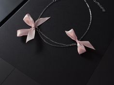 Rannka's dusty pink bow necklace with ribbons is a thoughtful romantic birthday gift and anniversary jewelry for a girlfriend. The silver jewelry piece is ideal for youth, and a charming summer elegant chain necklace.  𝐒𝐈𝐙𝐄: ➤ Adjustable Fits Circumference from 16″ - 20″ (40.6cm - 50.8cm)  𝐃𝐄𝐓𝐀𝐈𝐋𝐒: ➤ Materials: Stainless Steel, Ribbon ➤ Ready to Ship -The Rannka Bow Necklace features two dusty pink ribbon bows and a double stainless steel chain design. -Great for a fun summer day and night.  𝐒𝐔𝐆𝐆𝐄𝐒𝐓𝐄𝐃 𝐂𝐀𝐑𝐄: Use water and a drop of mild detergent. Rinse, then line dry. Always make sure to wipe off water and dry your jewelry completely after cleaning. Do not use any products containing alcohol. Be sure to take off your jewelry before swimming, showering, etc.  𝐂𝐎𝐎? Delicate Choker Necklace, Romantic Birthday Gifts, Arm Cuff Bracelet, Bow Choker, Delicate Choker, Tout Rose, Ribbon Choker, Choker Silver, Romantic Birthday