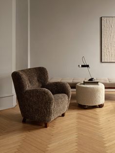 a living room with two chairs and a ottoman