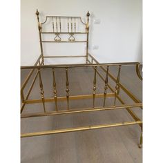 a gold metal bed frame with four posts