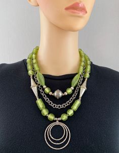 One-of-a-kind handcrafted multi-strand statement necklace. Beads: 3 strands of German lampwork glass, Afghan silver, Murano glass, sterling silver pendant, with silver-plated chain Dimensions: approximately 21" with 2" pendant + 2.5" extender Make a Statement with this elegant necklace! ﻿Free Shipping ﻿Refund Policy Artisan Double Strand Silver Necklaces, Artisan Double Strand Silver Necklace, Artisan Silver Double Strand Necklace, Multi-strand Czech Glass Jewelry With Large Beads, Czech Glass Large Beads Multi-strand Jewelry, Handmade Multi-strand Glass Jewelry, Multi-strand Glass Beaded Jewelry, Multi-strand Glass Bead Jewelry, Unique Silver Multi-strand Beaded Necklaces