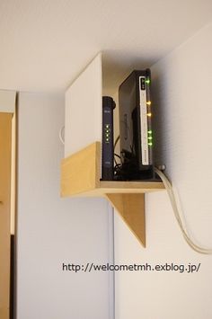 there is a small shelf with a router on it and wires attached to the wall