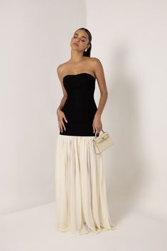 Introducing the Black Strapless Cream Chiffon Maxi Dress, a graceful blend of modern simplicity and timeless elegance. This stunning dress features a sleek, strapless black bodice that accentuates the shoulders and waist, providing a smooth and flattering silhouette. The bodice seamlessly transitions into a flowing cream chiffon maxi skirt that cascades to the floor, creating a soft, ethereal movement with every step. The contrast between the bold black top and the delicate cream skirt adds a sophisticated touch, making this dress perfect to dress down for the day or to dress up for formal events, galas, or evening soirées. Embrace effortless style with this versatile and elegant piece. Heiress Beverly Hills, Corset Pants, Chiffon Maxi Skirt, Cream Skirt, Dresses Xxl, Chiffon Maxi, Chiffon Maxi Dress, Bold Black, Blazer Dress