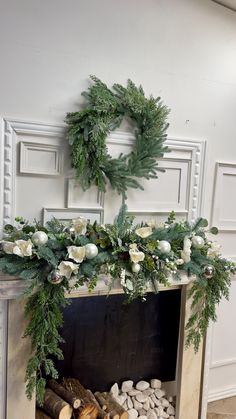 a fireplace decorated with greenery and white flowers