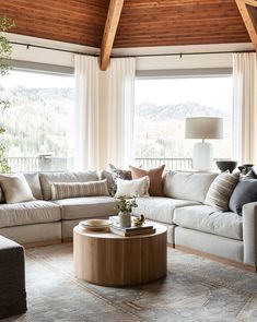 a living room filled with furniture and large windows