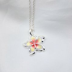 This Sterling Silver Rainbow Plumeria Necklace is the perfect accessory for any special occasion. Featuring vibrant colors and delicate craftsmanship, this Hawaiian jewelry is perfect for any fan of elegant jewelry. An ideal gift for yourself or a special someone, this plumeria pendant is sure to make a lasting impression. - Comes ready to wear on a 925 sterling silver chain of you choice length. Comes standard on a box style chain.  - solid sterling silver plumeria flower pendant accented with a cz   Approx 20 mm in size Custom made to order so yours may look slightly different from the above pictures. Due to different monitors and settings colors may appear slightly different. Silver Flower Pendant Necklace As Gift For Her, Silver Flower Charm Necklace As Gift For Her, Silver Flower Necklace Gift For Mom, Silver Flower Necklace For Mom, Delicate Multicolor Jewelry For Gifts, Multicolor Delicate Jewelry Gift, Silver Flower Pendant Necklace As Gift, Silver Flower Necklace Gift For Her, Silver Pendant Flower Necklace As Gift For Her