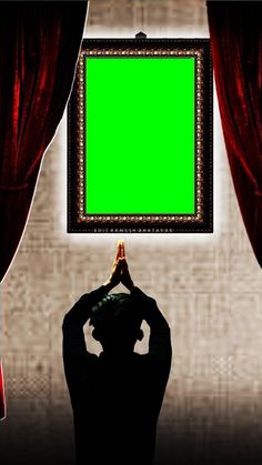 a person standing in front of a green screen with their hands up to the ceiling