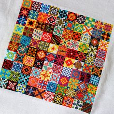 a colorful patchwork quilt is displayed on a white cloth