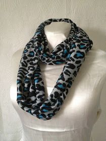 a white mannequin with a black and blue leopard print scarf on top of it