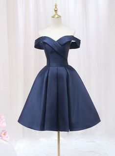 Honor your sophisticated style with this exquisite navy blue homecoming dress. The off-the-shoulder neckline creates a chic and timeless look, perfectly framing your shoulders and collarbone. The bodice is adorned with a unique wrap design that cinches at the waist, providing a flattering and comfortable fit. The full, pleated skirt adds a touch of vintage elegance, allowing for beautiful movement as you dance or walk. The rich navy satin fabric gives the dress a luxurious feel and a subtle sheen, ensuring you stand out in any crowd. This dress combines elegance and comfort, making it perfect for a night of celebration. Ideal for those who appreciate classic beauty with a modern twist, this homecoming dress will make you feel like royalty. Make a lasting impression with this stunning piece Navy Dama Dresses, Navy Blue Dama Dresses, Elegant Blue Off Shoulder Dress For Prom Season, Elegant Blue Knee-length Off Shoulder Dress, Elegant Off-shoulder Strapless Dress For Homecoming, Elegant Off Shoulder Dress For Homecoming And Prom, Elegant Off-shoulder Dress For Prom And Homecoming, Damas Dresses For Quince, Quinceanera Dama Dresses