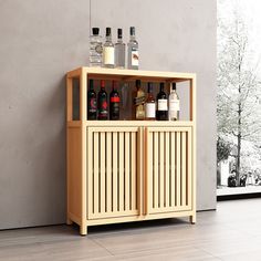 a wooden cabinet with bottles on top of it next to a wall in a room