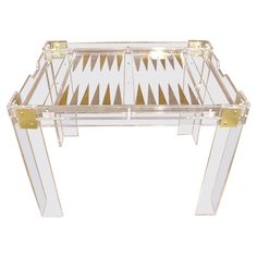 a clear and gold glass table with two legs on each side, in the shape of a checkerboard pattern