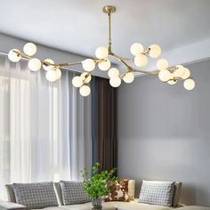 a living room filled with furniture and a chandelier hanging over the top of it