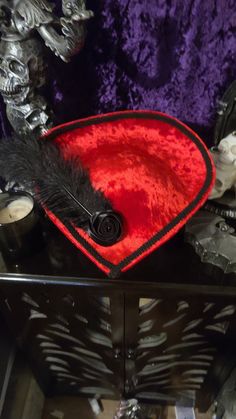 Beautiful Red Velvet Victorian Inspired Hat with a Black Rose and Black Feather. Perfect for dressing up, Afternoon Tea, formal events, Vampire Balls, and cosplay. Other styles are available in all colors. Message me for a custom order. Made in a pet friendly studio. Made to order, 3 to 5 days creation time  Check out my other listings: Black Velvet Victorian with Tassels: https://www.etsy.com/listing/1197594531/black-velvet-formal-hat-velvet-top-hat Silver Victorian: https://www.etsy.com/listing/1293744756/victorian-hat-edwardian-hat-downton Mauve Victorian:  https://www.etsy.com/listing/1293745798/mauve-velvet-hat-formal-hat-red-top-hat Burgandy Victorian:  https://www.etsy.com/listing/1094341893/victorian-hat-edwardian-hat-downton Turquoise Peacock: https://www.etsy.com/listing/11014448 Fitted Red Costume Accessories For Themed Events, Red Fitted Costume Accessories For Themed Events, Red Hats For Carnival Costume Party, Red Costume Hats And Headpieces For Carnival, Red Costume Hat For Halloween Themed Events, Red Costume Hats And Headpieces For Halloween, Red Adjustable Hat For Costume Party, Red Costume Hat, Fitted Red Costume Hats And Headpieces For Costume Party