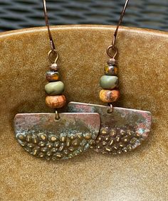 Rustic antique Hammered copper dangle earrings with jasper stones.  Looking for something lightweight, unique and natural? This simple yet elegant pair of hammered copper earrings will definitely make you smile!  These earrings have a very unique hammered texture. The color of the copper changes with the light. They have an antique patina finish for a rustic look. The stones are varieties of jasper.  These earrings are 1 inch in diameter. They are very light weight, less than 3 grams. The French Copper Dangle Earrings With Patina, Copper Dangle Jewelry With Patina, Earthy Nickel-free Copper Jewelry, Earthy Metal Dangle Earrings, Artisan Copper Dangle Hoop Earrings, Hand Forged Copper Dangle Hoop Earrings, Hand Forged Copper Hoop Earrings With Dangle, Unique Rust-colored Earrings With Ear Wire, Unique Rust Earrings With Ear Wire