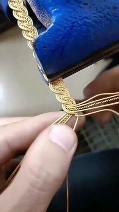 a person is working on some gold chains