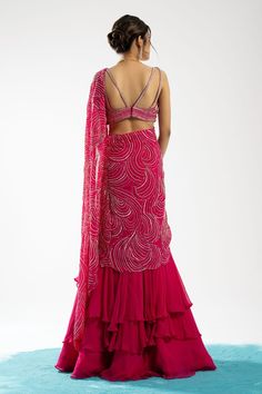 Fuchsia pink pre-draped tiered lehenga saree with circular motifs embroidered in pearls and sequins. Comes with embroidered blouse.
Component: 2
Pattern: Embroidery
Type Of Work: Pearls, Sequins
Sleeve Type: Sleeveless
Fabric: Blouse: Tussar, Saree: Organza and Chiffon
Color: Fuchsia
Other Details: 
Ruffle detailing
Note: The bag shown in the images is not for sale
Occasion: Destination Wedding - Aza Fashions Pearls Blouse, Tiered Lehenga, Saree Organza, Tussar Saree, Ruffle Saree, Drape Saree, Sequin Sleeve, Lehenga Saree, Color Fuchsia