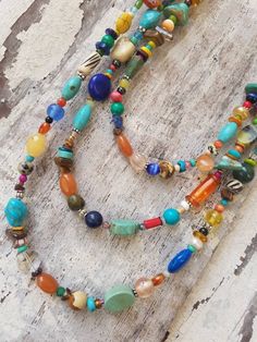 "Three pretty graduated strands of multi color, semi precious stones make up this long bold necklace. Just about every stone you can imagine, turquoise, garnet, lapis, pearls, chrysoprase, red coral, and carnelian, just to name a few. The stones are accented with Bali sterling silver fancy spacers. The necklace measures 33\" in total length. The longest strand measures 33\" the middle strand measures 30\" and the shortest strand measures 27\". All three strands are connected with a sterling silv Artisan Multicolor Necklaces With Natural Stones, Bohemian Gemstone Long Necklace For Jewelry Making, Artisan Multicolor Beaded Necklace With Natural Stones, Bohemian Long Necklace With Round Gemstone Beads, Bohemian Multicolor Turquoise Necklace With Round Beads, Colorful Bohemian Gemstone Jewelry, Bohemian Long Necklace With Gemstone Round Beads, Multicolor Bohemian Turquoise Necklace With Round Beads, Bohemian Multicolor Round Beads Long Necklace