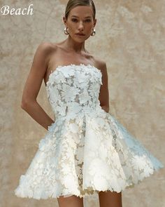 a woman in a short white dress with flowers on it