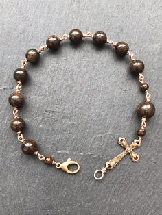 Cross rosary bracelet Solid bronze medal Bronze Wire Bronzite gemstones *All bracelets and necklaces can be adjusted to any size. Please send me a message with your desired length. Adjustable Gold Hand Wrapped Rosary Bracelet, Adjustable Rose Gold Spiritual Rosary, Gold Rosary Bracelet With Natural Stones And Round Beads, Adjustable Gold Rosary Bracelet With Natural Stones, Spiritual Rose Gold 8mm Beads Jewelry, Spiritual Rose Gold 8mm Beaded Jewelry, Spiritual Rose Gold Jewelry With 8mm Beads, Nickel-free Bronze Spiritual Bracelets, Spiritual Bronze Nickel-free Bracelets