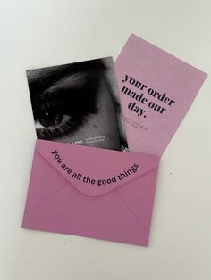 two pink envelopes with black and white images on them, one has a card that says you're all the good things