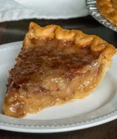 a piece of pie sitting on top of a white plate next to another pie dish