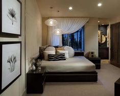 a bedroom with a large bed and pictures on the wall