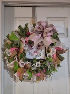 a wreath is hanging on the front door with ribbons around it and a photo in the center