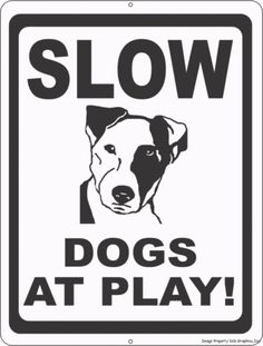 a black and white sign with the words slow dogs at play written in large letters