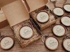 six wooden keychains are sitting on a table next to some boxes with tags in them