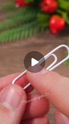 a person holding a paper clip in their hand