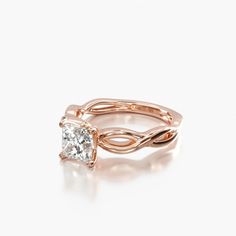 a rose gold engagement ring set with a princess cut diamond in the center and twisted band