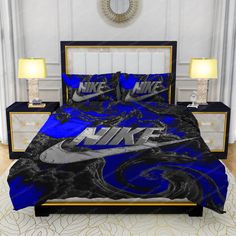 a bed with a blue and black nike comforter set on it in a bedroom