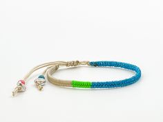 This beige bracelet with glitter blue yarn is comfortable to wear and lightweight around the wrist with adjustable sliding knot closure so fits most sizes both women, men and children. It harmonizes with every outfit, every occasion, also perfect as a gift for your loved ones. Wrapped length 13cm, extension braided length 11cm, width 0.4cm Designed and made in a smoke free - pet free environment.  All our products are nickel free and kind to the skin.  Each bracelet is unique and handmade, there Blue Bohemian Jewelry With Sliding Knot, Blue Bohemian Friendship Bracelets For Summer, Bohemian Blue Friendship Bracelets For Summer, Turquoise Bohemian Braided Bracelets For Summer, Bohemian Blue Jewelry With Sliding Knot, Blue Bohemian Braided Bracelets For Beach, Blue Beaded Bracelets With Adjustable Cord For Festival, Adjustable Blue Beaded Bracelets Hippie Style, Blue Bohemian Braided Bracelet For Beach