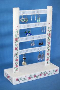 a white jewelry rack with earrings on it