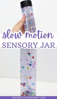 a hand holding a glass bottle with the words slow motion sensory jar in front of it