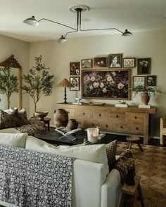 a living room filled with lots of furniture and pictures on the wall above it's coffee table