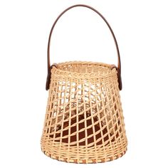 a wicker basket with leather handles on a white background