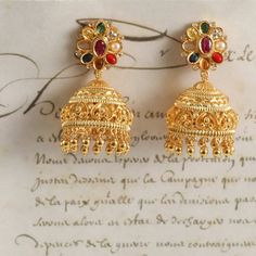 Description: Embrace the essence of tradition with these stunning Navaratna jhumka earrings crafted in Hallmark 925 Silver. The top features a dazzling arrangement of colorful Navaratna stones, radiating elegance and vibrancy. The classic jhumka design cascades down gracefully, embodying the charm of heritage jewelry. Perfect for festive celebrations or special occasions, these earrings will beautifully complement any ethnic ensemble. Product Information: Metal: 925 Silver with Gold Plating Ston Multicolor Chandbali Jhumkas With Intricate Design, Multicolor Fusion Style Festive Jhumkas, Festive Multicolor Fusion Style Jhumkas, Temple Jewelry Jhumkas For Navratri, Temple Jewelry Style Jhumkas For Navratri, Temple Style Drop Jhumkas For Navratri, Temple Style Jhumkas For Navratri, Multicolor Fusion Jhumkas For Diwali, Fusion Style Multicolor Jhumkas For Diwali