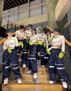 a group of women standing on top of a set of stairs wearing blue and white outfits