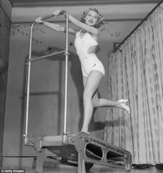 a woman in a bathing suit standing on a ladder