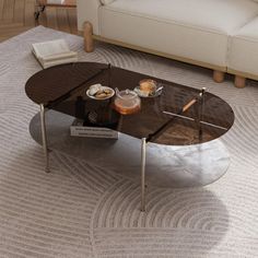 a coffee table sitting on top of a rug in a living room next to a couch