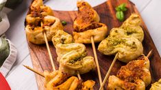 several skewered food items on a wooden cutting board