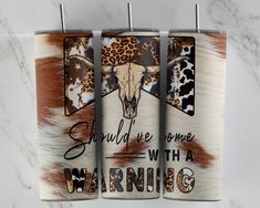 three cow print towels hanging on a rack with leopard and cheetah prints in the background