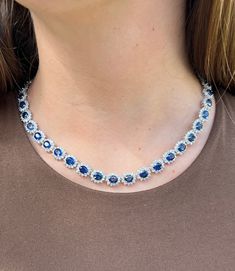 "Introducing a circle link 18k white gold choker necklace with natural Blue Sapphires and diamonds. 40 individual links each containing a vivid no heat Blue Sapphire. The Sapphires are oval cut, totaling approximately 36.0 carats total and measuring 6x5 mm. 4-prong set Blue Sapphire with 12 round cut diamonds forming a halo in a shared prong mounting. 480 diamonds totaling approximately 9.60 carats total. Diamonds are H-I color, SI1, - SI2 Clarity. Necklace set in 18k white gold, measuring 17 in Luxury Sapphire Color Diamond Cut Necklace, Sapphire Jewelry Chanel Choker, Luxury Blue Diamond Classic Necklace, Luxury Sapphire Color Diamond Necklace With Diamond Cut, Luxury Blue Diamond Necklace In Classic Style, Luxury Blue Diamond Necklace Classic Style, Luxury Sapphire Diamond Necklace With Diamond Cut, Luxury Blue Necklace With Pave Setting, Luxury Blue Diamond Cut Diamond Necklace