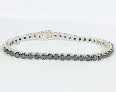 Unisex Tennis Bracelet Black Diamond 7.50 Inches In 925 Sterling Silver 4 mm AAA Diamond Color - Jet Black  Shape - Round Brilliant Cut  Size of Diamond - 4.00 mm  Weight of Diamonds - 12 carats appx. Length of Bracelet - 7.50 inches   Origin of Diamond - Central Africa (Conflict Free)  Species - Carbonado - Earth Mined  Quality - AAA  Metal - 925 Sterling Silver  CERTIFICATE OF AUTHENTICITY PROVIDED 100% Satisfaction guarantee WE SELL ONLY GENUINE DIAMOND. SOME MAY BE HEATED WHICH IS A COMMON AND ACCEPTABLE TREATMENT, OR BE FISSURE FILLED OR COLOR ENHANCED. WE DO NOT SELL SYNTHETIC OR LAB CREATED ITEMS AND ASSURE ALL DIAMOND ARE GENUINE. WE PROMISE 100% SATISFACTION GUARANTEE ON ALL PURCHASES. OUR GOAL IS QUALITY SERVICE, INTEGRITY AND COMPLETE CUSTOMER SATISFACTION. FOR ANY QUESTIONS DON Silver Certificate, Central Africa, Fine Jewelry Bracelets, Bracelet Black, Diamond Color, Tennis Bracelet, Jet Black, Black Diamond, Round Brilliant