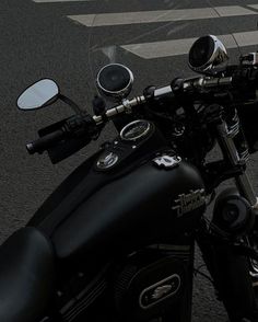 a black motorcycle parked on the street next to a crosswalk